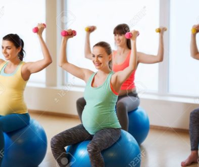 happy pregnant women exercising on fitball in gym